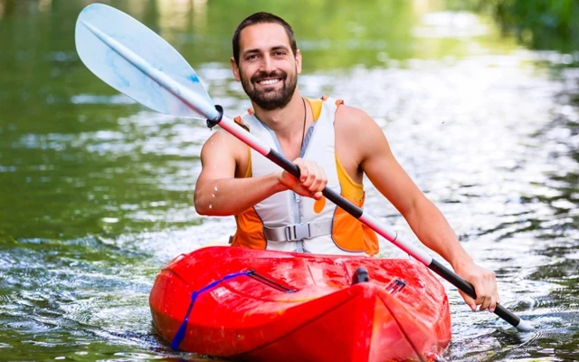 Un homme souriant fait du kayak
